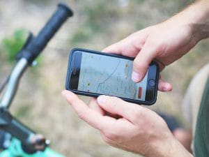 Un homme sur son vélo utilise une application sur son téléphone