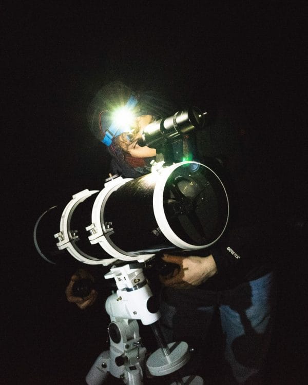 un homme de nuit regarde dans un télescope