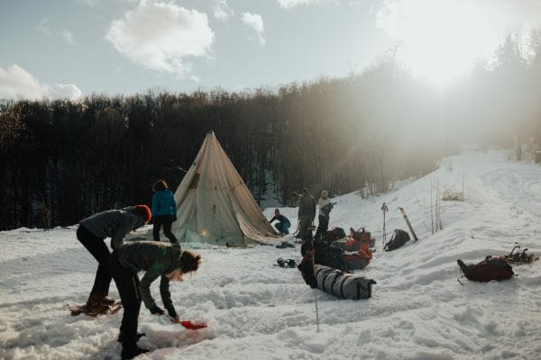 des personnes montent leur campement dans la neige